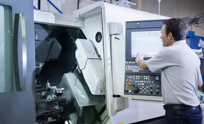 CNC machine operator programming machining center control panel in factory